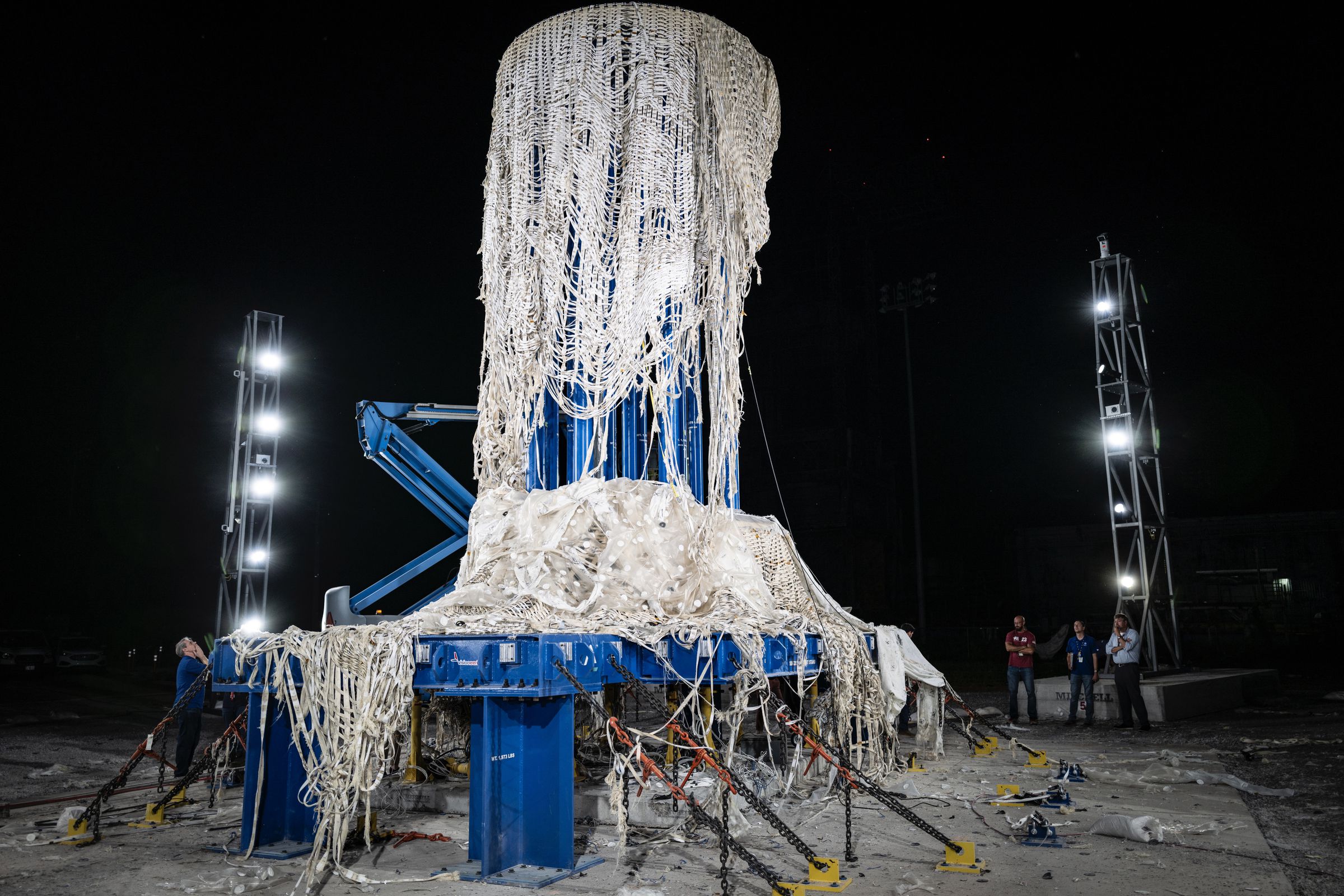 bursted LIFE structure, fabric weave is hanging from a blue platform